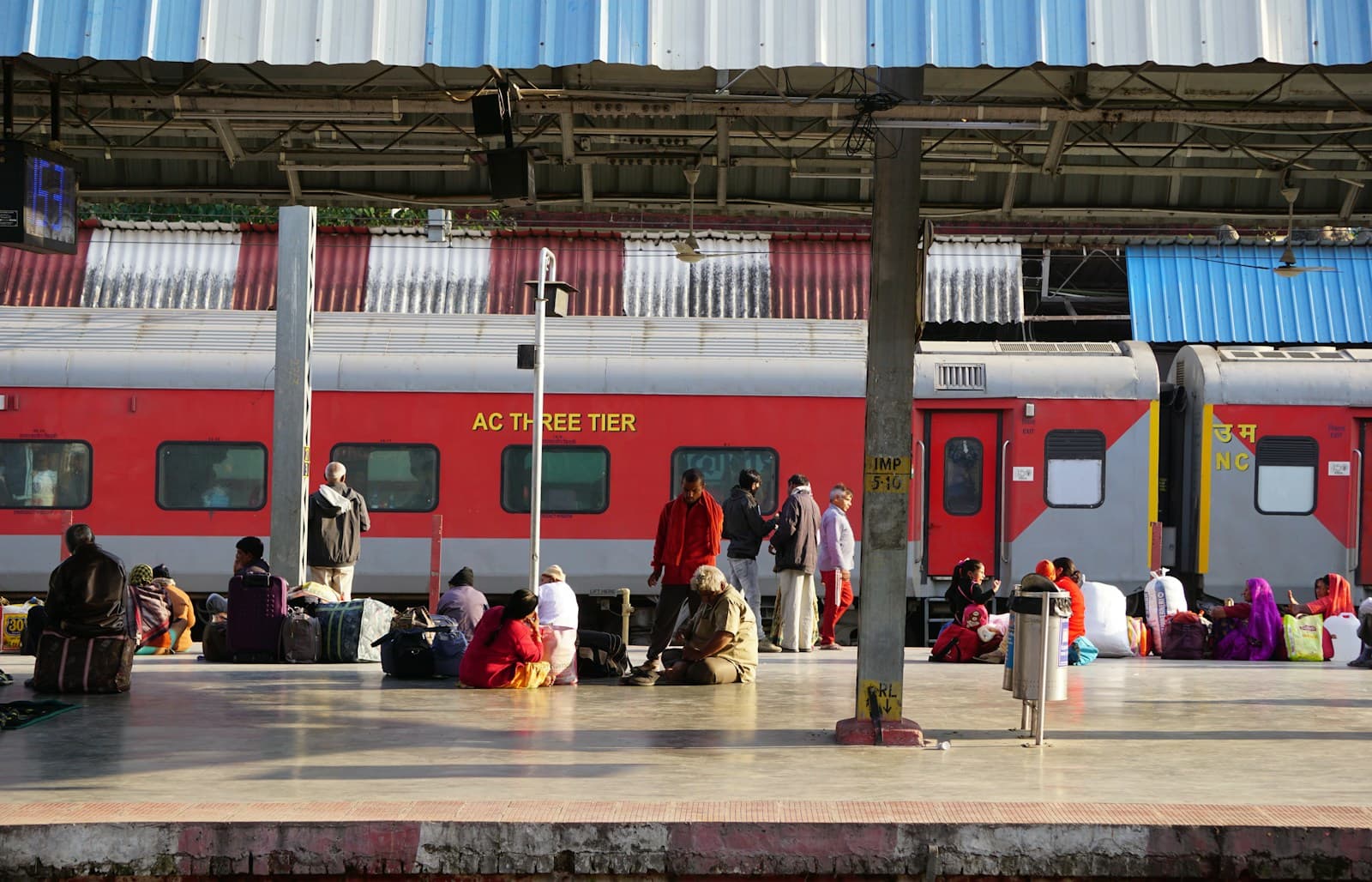 Passengers waiting on a railway platform beside a train