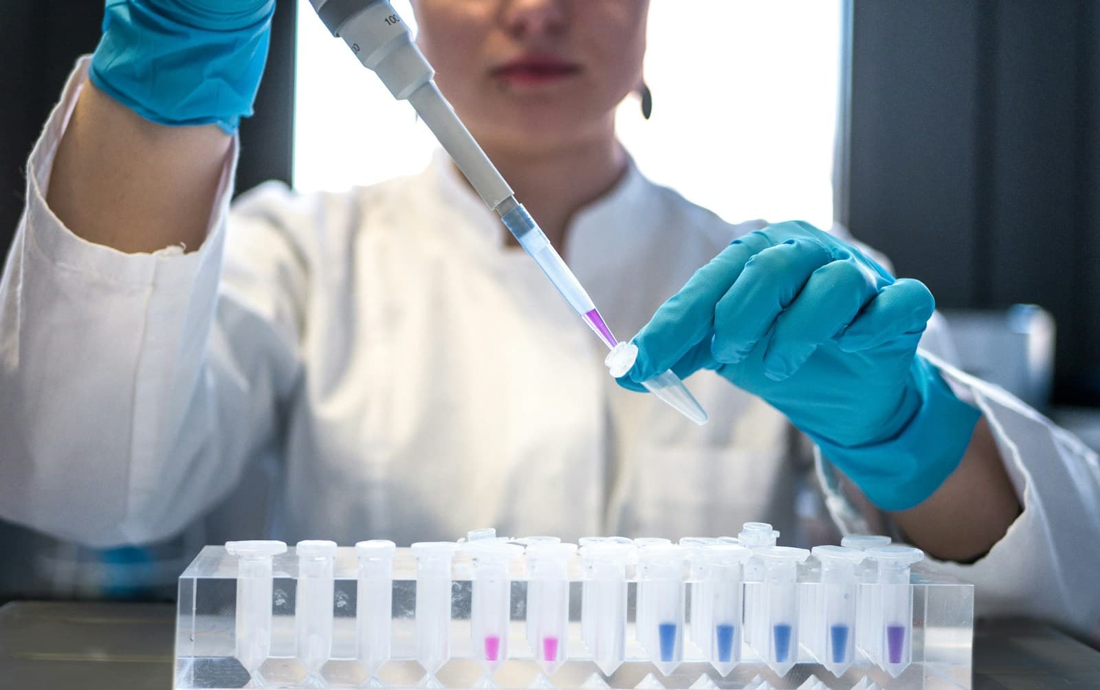 A researcher using a pipette at a laboratory bench